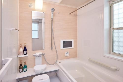 a bathroom with a tub and a toilet and a sink at とまりーとStay 立会川 Tomareat Stay Tachiaigawa in Tokyo