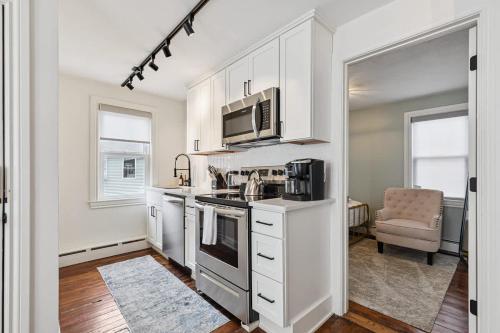 a kitchen with white cabinets and a microwave at Federal Hill PRIDE in Providence