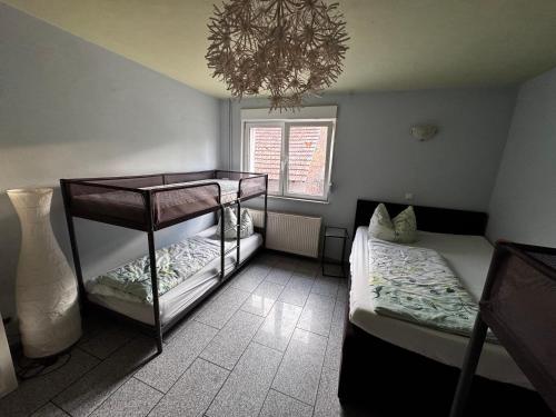 a bedroom with two bunk beds and a chandelier at Familyroom 6 P Free WiFi Gemeinschaftsbad in Hausbreitenbach