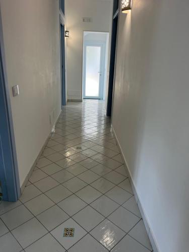 a hallway with a tile floor and an open door at Vincanto Maiori Costiera Amalfitana in Maiori