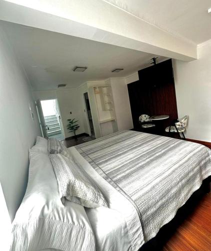 a bedroom with a large white bed in a room at Éclat Hotel Boutique in Iquique