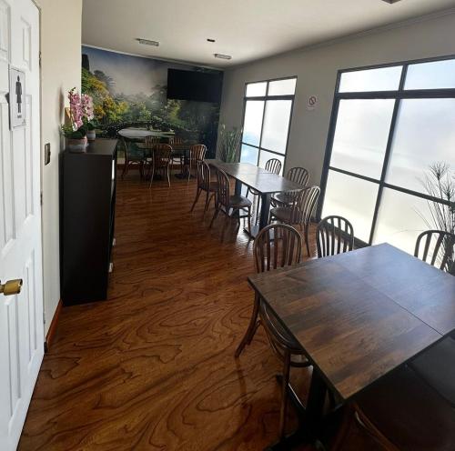 a dining room with tables and chairs and windows at Éclat Hotel Boutique in Iquique