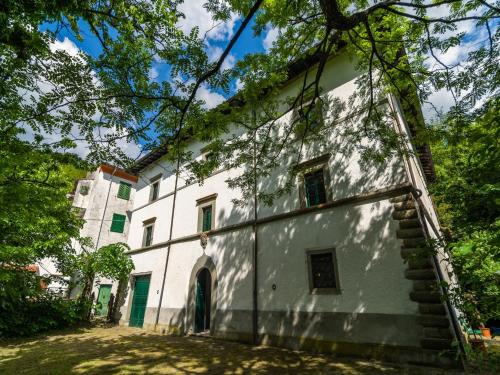 an old white building with trees in front of it at Spacious Villa Retreat in San Marcello Pistoiese