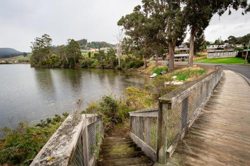 a bridge over a river with stairs next to the water at Bay View Retreats- Ocean mist in Dover
