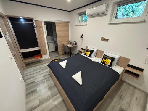 a bedroom with a bed and a couch and a tv at Május 1 Vendégház - Szombathely in Szombathely