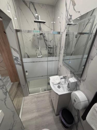 a bathroom with a shower and a sink and a mirror at Május 1 Vendégház - Szombathely in Szombathely
