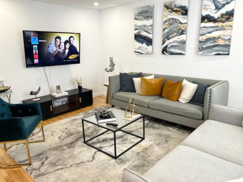a living room with a couch and a tv on a wall at Charming beautiful house 7mn to downtown Ottawa in Gatineau