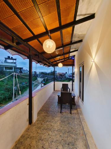 a balcony with a table and chairs and a view at Luxury Heaven Valley in Kodaikānāl