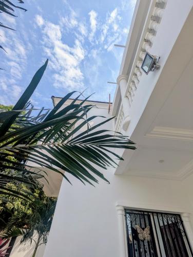 a view of a white building with a palm tree at Heather's Retreat in Brufut