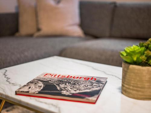 a book sitting on top of a coffee table at Bloomfield, Pittsburgh Large and Accessible 3 Bedroom Apr with Free Parking in Pittsburgh