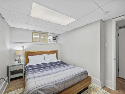 a bedroom with a bed in a white room at Bloomfield, Pittsburgh Large and Accessible 3 Bedroom Apr with Free Parking in Pittsburgh