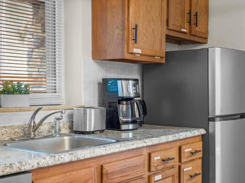 a kitchen with a sink and a refrigerator at Bloomfield, Pittsburgh Large and Accessible 3 Bedroom Apr with Free Parking in Pittsburgh