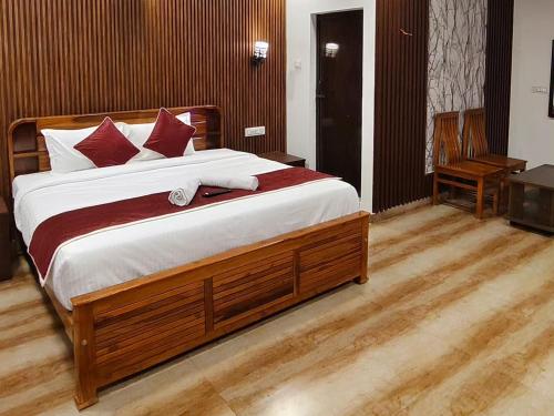 a bedroom with a large bed with red and white pillows at Luxury Heaven Valley in Kodaikānāl