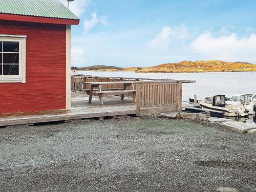 a wooden dock with a bench next to a red building at 6 person holiday home in Oksvoll in Oksvoll