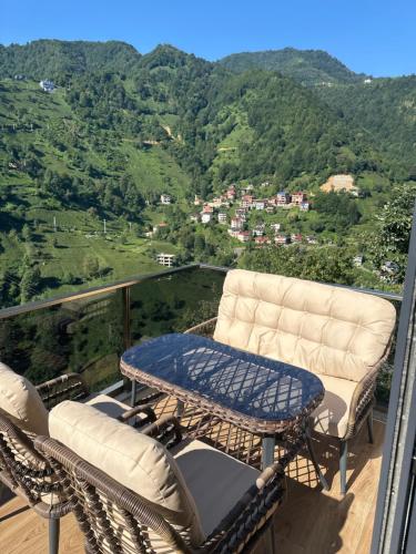 a balcony with two chairs and a table with a view at Sunshine Suit Bungalov in Ardeşen