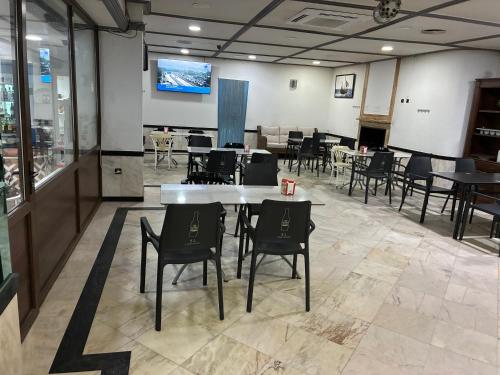 a dining room with tables and chairs and a tv at Hostal Restaurante La Niña in Palos de la Frontera