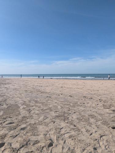 a sandy beach with people walking on the beach at Heather's Retreat in Brufut