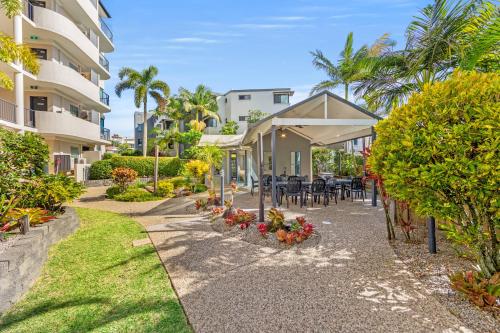 a walkway in front of a building with tables and chairs at Alexandra on the Pacific in Mooloolaba