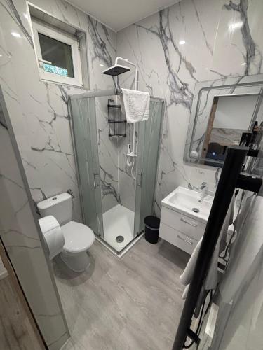 a bathroom with a shower and a toilet and a sink at Május 1 Vendégház - Szombathely in Szombathely
