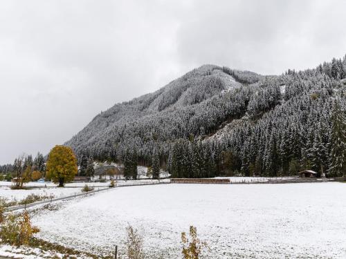 a snow covered field in front of a mountain at Chalet in Saalbach near Ski Lift in Saalbach Hinterglemm