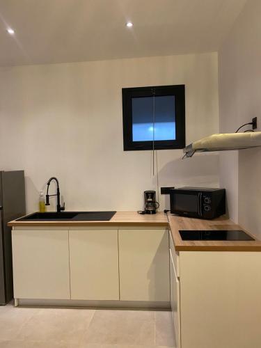a kitchen with a sink and a microwave at Mareva in Hell-Ville
