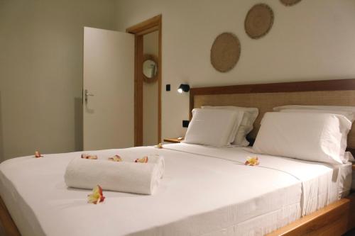 a large white bed with two towels on it at Mareva in Hell-Ville