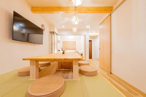 a dining room with a wooden table and chairs at 春 家族グループ向け 弁天町駅近3LDK 大型和風バスルーム 2バス usj好アクセス 駐車場無料 in Osaka