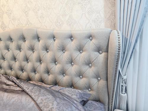a bedroom with a bed with a beige headboard at Elegant 3 Bedrooms Home near MRT Central WestGate and Central WestVille 3 to 10 Min Drive 