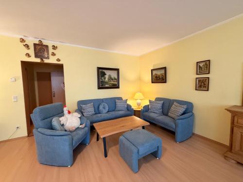a living room with two blue couches and a table at Hotel Am Sportpark in Duisburg