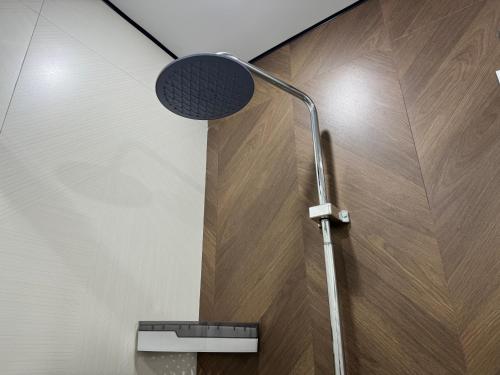 a shower in a bathroom with a light on the wall at Damir hotel in Aktobe