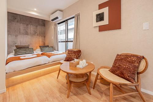 a bedroom with a bed and a table and chairs at Mi-HOTEL SUGAMO in Tokyo