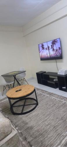 Kitengela にあるThe Unwind Spot Kitengelaのリビングルーム(テーブル、薄型テレビ付)