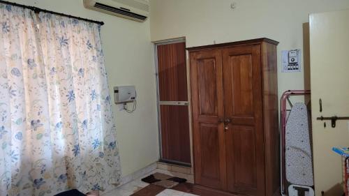 a room with a curtain and a wooden cabinet at THE 101 HOMESTAY, Calangute by ROSH HOSPITALITY in Calangute