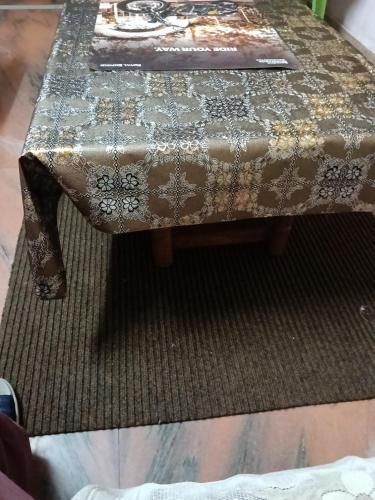 a table with a table cloth on top of a rug at Resort Shine Astha with garden and mountain view, Pet friendly in Manāli