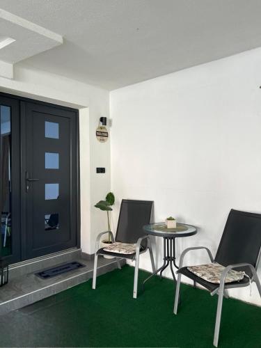 a room with two chairs and a table and a door at Apartman Eterna in Bijeljina
