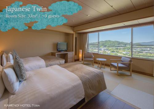 two beds in a room with a large window at KAMENOI HOTEL Toba in Toba