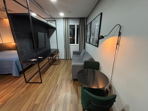 a living room with a couch and a flat screen tv at Hotel Wynd Al Campinas Paulista Luxuoso com garagem piscina 1102 in Sao Paulo