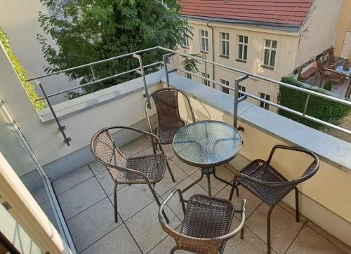 Un patio con sillas y una mesa en un balcón. en Quiet Central Stay & Parking Assistance, en Praga