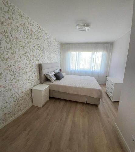 Un dormitorio con una cama grande y una ventana. en Smuuli Päikesepesa, en Kuressaare