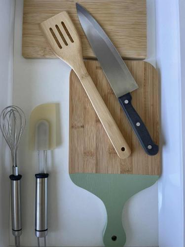 un cuchillo y una espátula sobre una tabla de cortar de madera en Smuuli Päikesepesa, en Kuressaare
