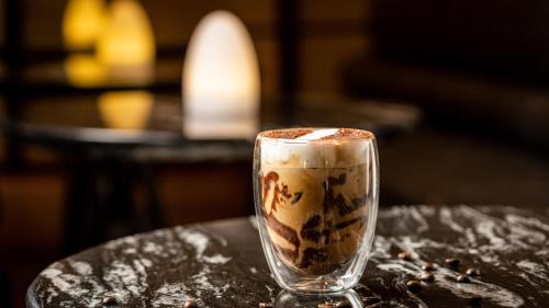 a glass cup of coffee sitting on a table at Crowne Plaza Hangzhou Riverside by IHG in Hangzhou