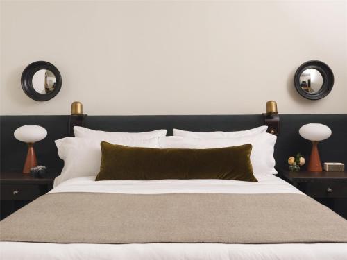 a bedroom with a black and white bed with two mirrors at The Bellevue Hotel, in the Unbound Collection by Hyatt in Philadelphia