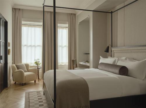 a bedroom with a large white bed and a chair at The Bellevue Hotel, in the Unbound Collection by Hyatt in Philadelphia