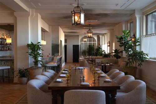 a restaurant with a long table and chairs at The Bellevue Hotel, in the Unbound Collection by Hyatt in Philadelphia