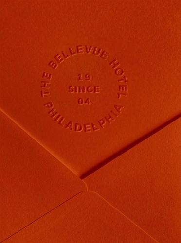 a close up of the top of an orange envelope at The Bellevue Hotel, in the Unbound Collection by Hyatt in Philadelphia