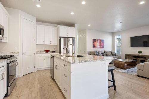 une cuisine avec des placards blancs et un îlot de cuisine dans l'établissement Holiday Hideaway townhouse, à Harrisburg Junction