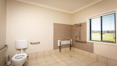 a bathroom with a toilet and a window at 'Mandalay Villa 2' in Paxton
