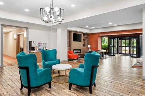 a living room with blue chairs and a table at Comfort Inn Largo-Washington DC East in Upper Marlboro