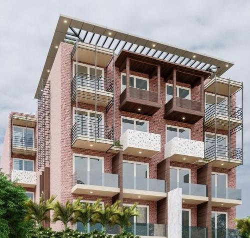 a tall brick building with balconies on it at The Tomo Inn in Gurgaon