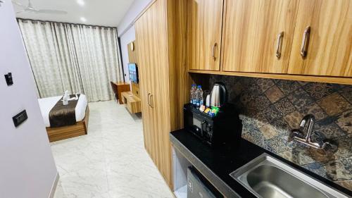 a kitchen with a sink and a bathroom with a bed at The Tomo Inn in Gurgaon